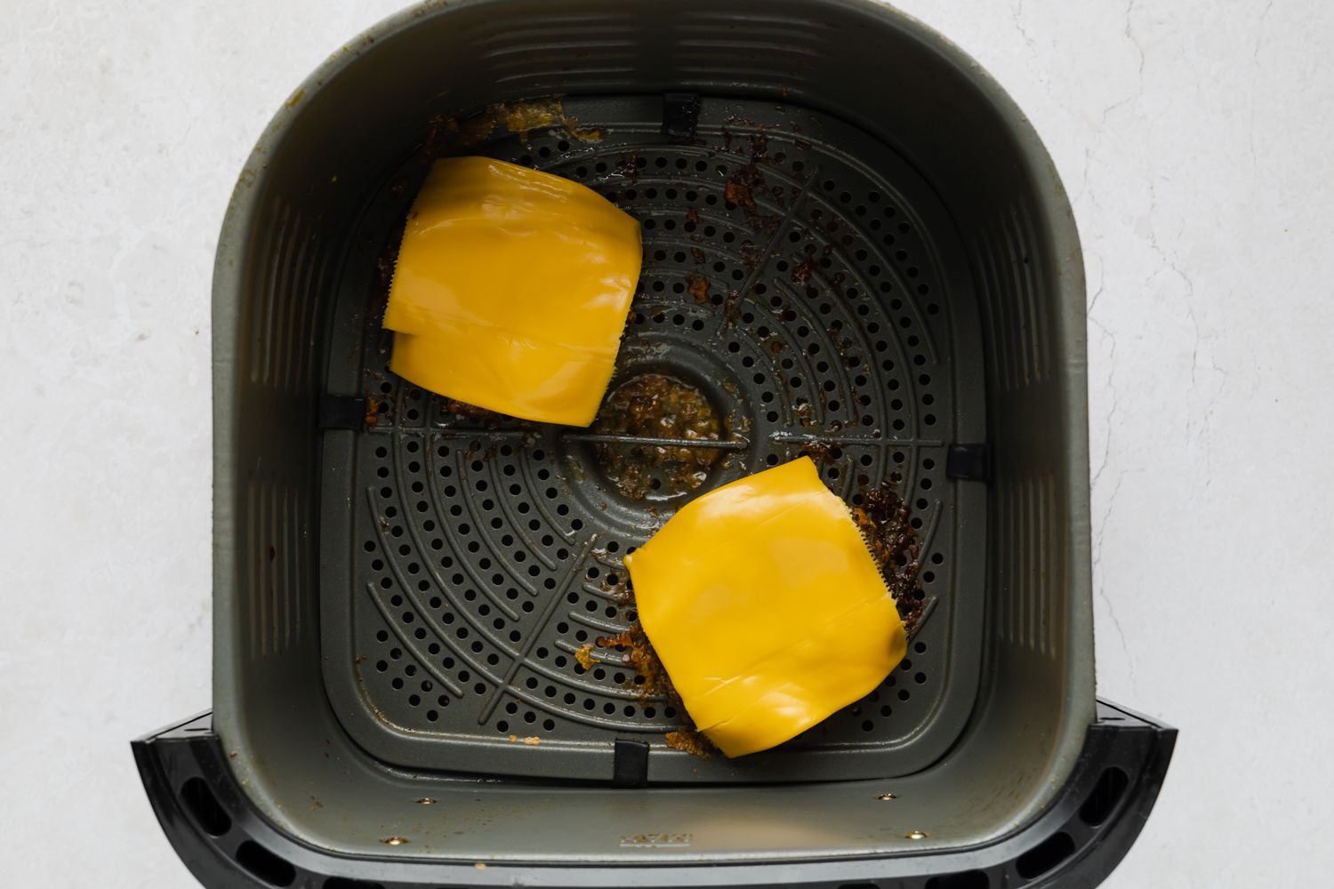 burger patties with cheese on top in an air fryer 