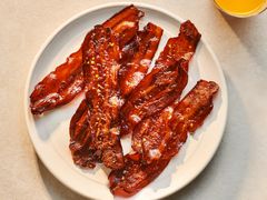 A plate of Millionaire's Bacon served with orange juice