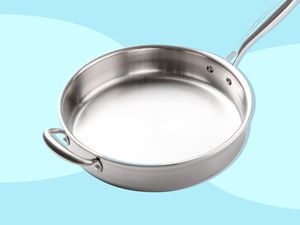 Stainless steel pan on light blue background