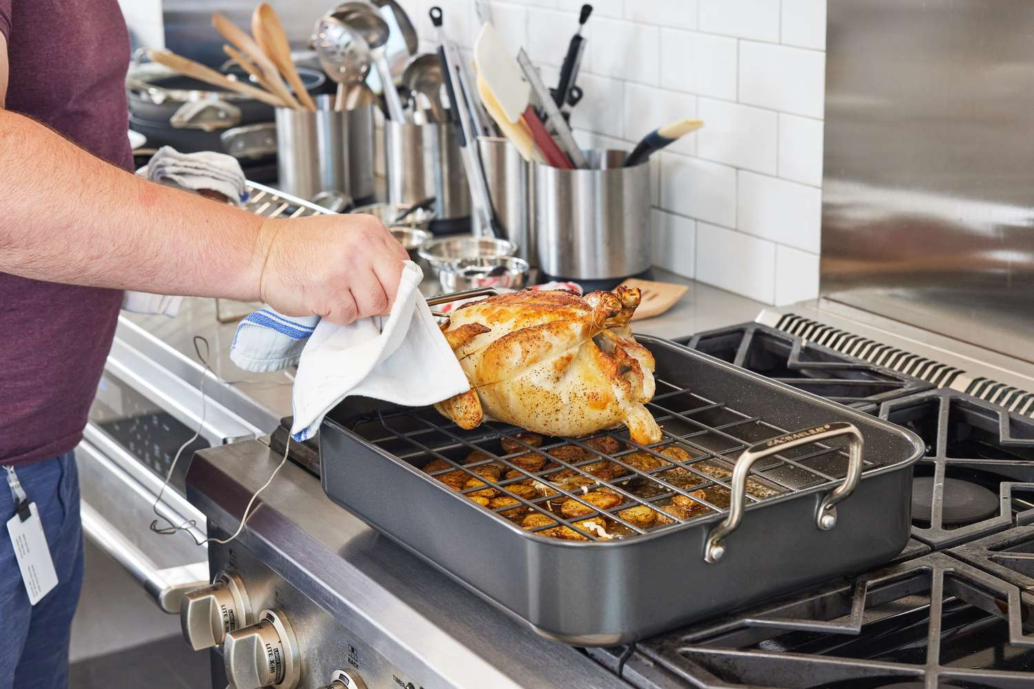 Person checking the temperature of a chicken in the Rachael Ray 16" x 13" Roaster with Dual-Height Rack