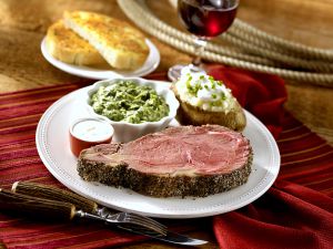 Prime rib with baked potato and creamed spinach on a plate