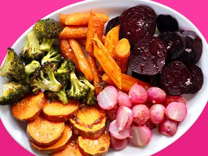 A platter loaded with roasted vegetables: broccoli, carrots, halved radishes, sweet potato rounds, and beet rounds