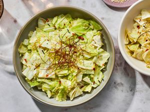 Two bowls of Yamitsuki (addictive cabbage), garnished with chile threads, dried red chiles, and roasted sesame seeds