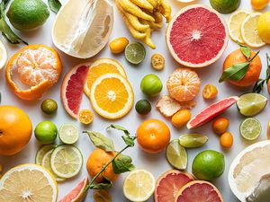 Variety of citrus fruits whole, cut in half and quarters and peeled