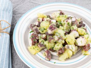 Octopus and potato salad on white plate