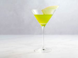 Japanese slipper cocktail in martini glass with a sliced melon garnish