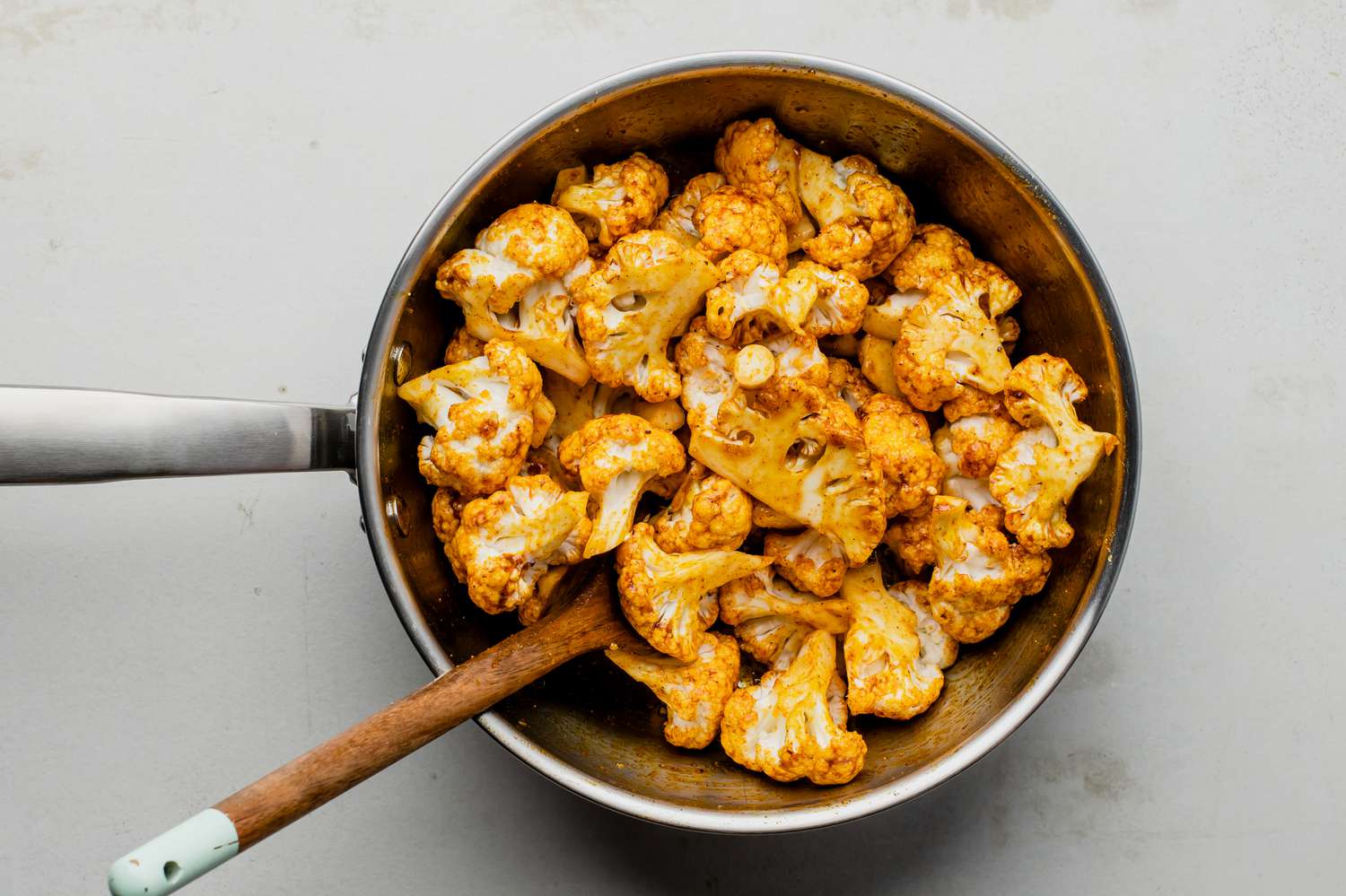 Cauliflower florets tossed in spicy buttery sauce in a saucepan