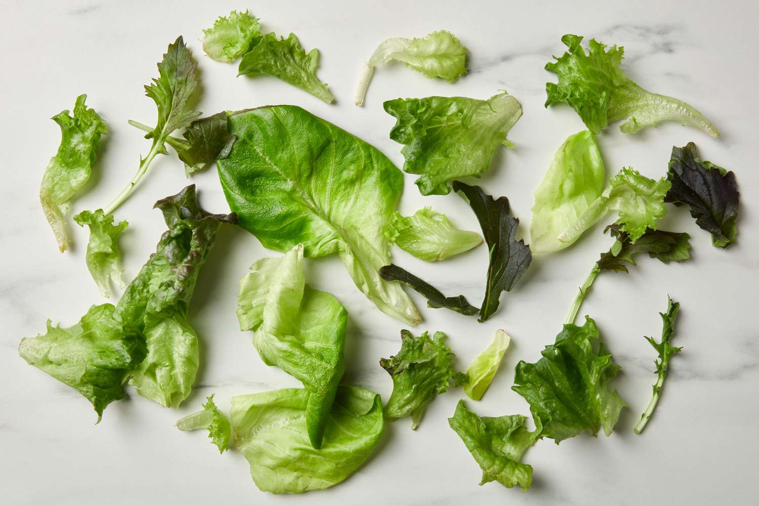 Spring mix lettuce scattered on a marble surface