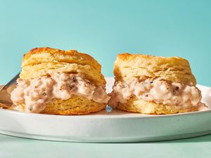 A plate with two flaky biscuits filled with sausage gravy