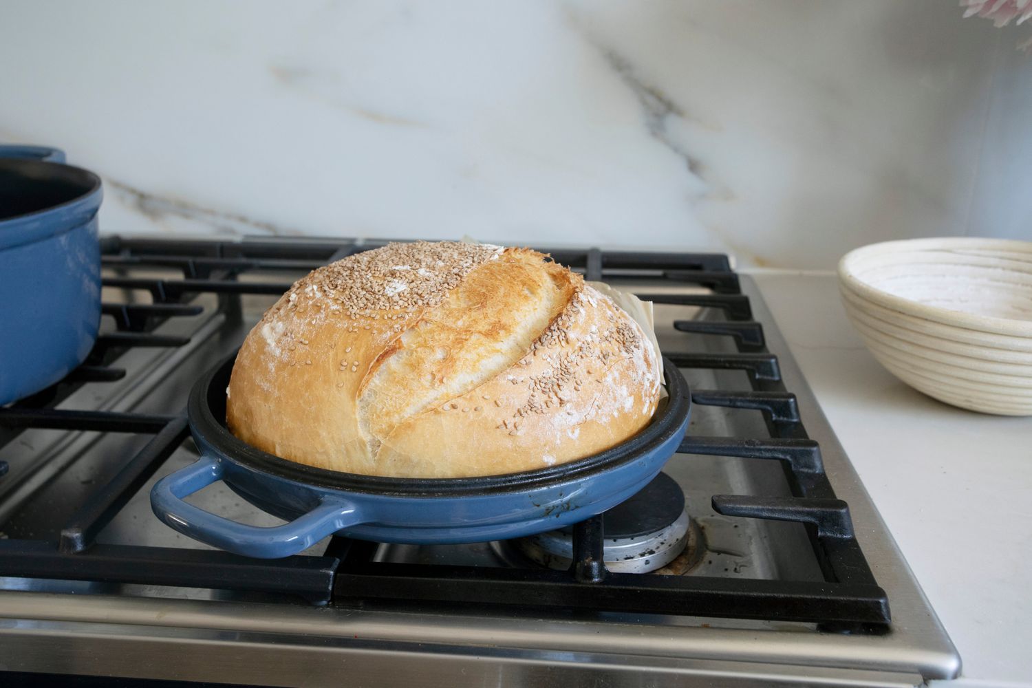 Blue Our Place Cast Iron Hot Grill sitting on stovetop with bread loaf inside of it