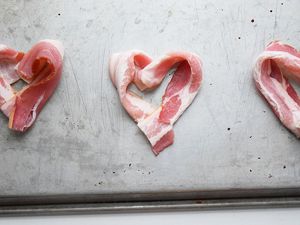 Bacon shaped like hearts on tray.