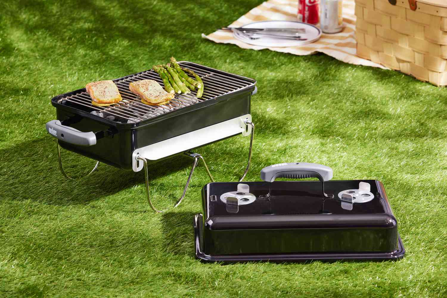 Weber Go-Anywhere Charcoal Grill with food in it on a lawn