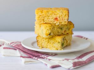  Slices of Mexican cornbread with jalapeños stacked on a plate