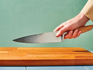 Someone holding a chef's knife with the blade grip