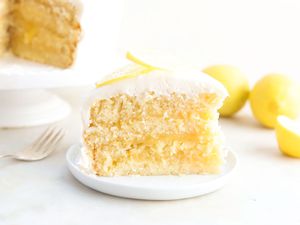 A slice of lemon curd cake, topped with sliced lemon