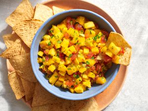 A bowl of mango salsa served with tortilla chips