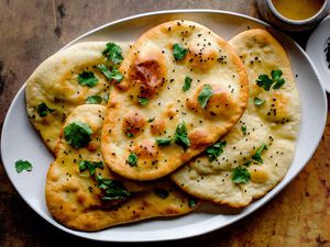 Naan leavened Indian flatbread recipe on a white oval platter