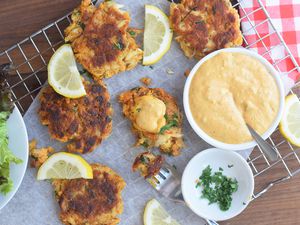 Crab cakes sauce with crab cakes, lettuce, chopped parsley, and lemon slices