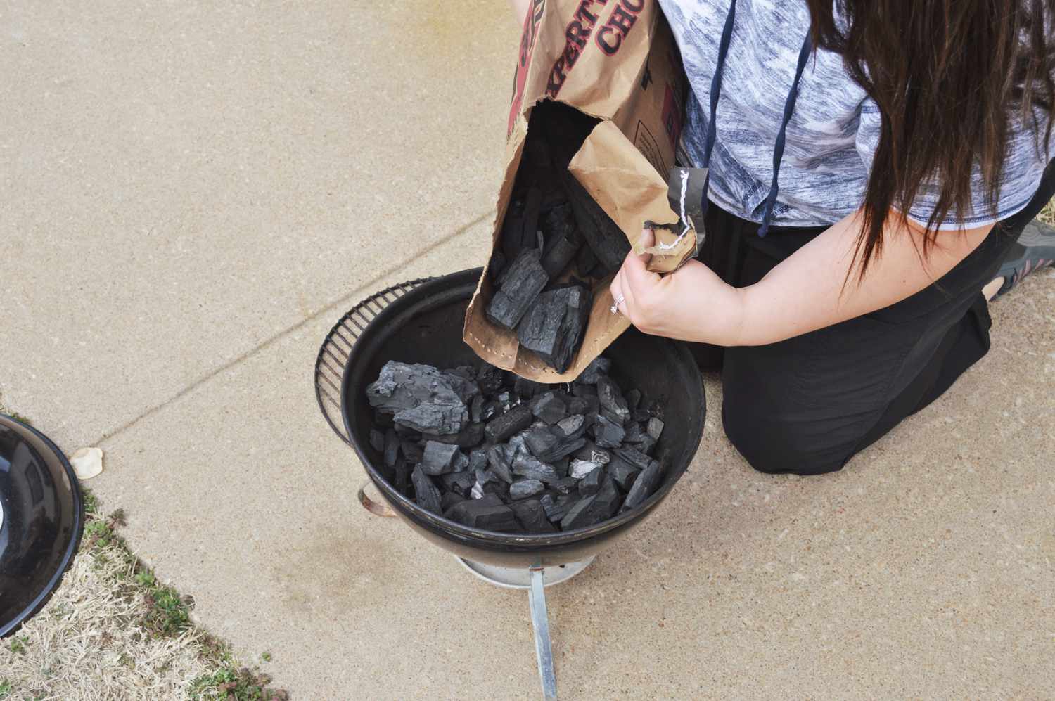 Person pouring B&B Charcoal Oak Lump Charcoal into grill