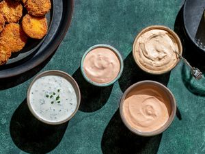 four dipping sauces for fried green tomatoes in small bowls with fried green tomatoes on plate