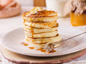 Stack of yogurt pancakes with butter and maple syrup