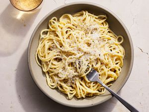 Cacio-e-pepe served in low bowl, topped with Pecorino Romano cheese.