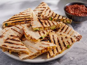 A plate with grilled zucchini and corn quesadillas, served with salsa