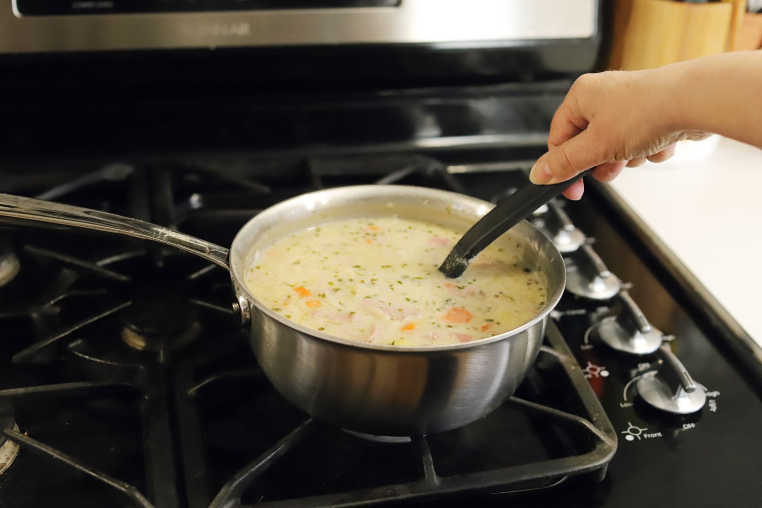 Hand stirring soup in the All-Clad G5 saucier