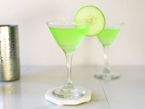 Two apple martinis with a slice of apple on the rim