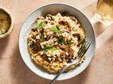 A bowl of mushroom risotto topped with parmesan cheese and parsley