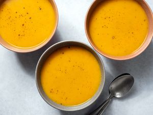 Three bowls of savory vegan butternut squash and carrot soup 