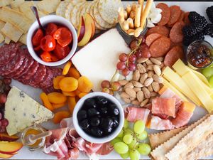 Charcuterie board filled with cheese, meat, nuts, and fruits