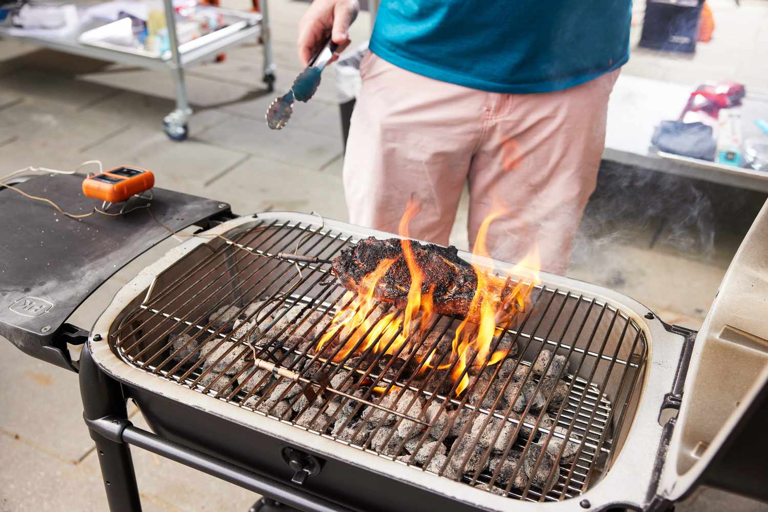 A person grilling on the PK Grills PKGo Camp & Tailgate Grilling System