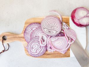 sliced red onions on cutting board
