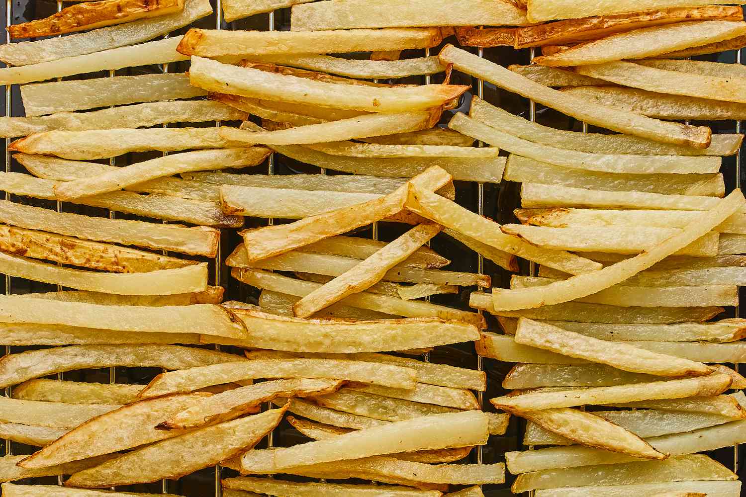 Draining par-cooked fries on a metal rack