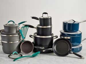 Several nonstick cookware sets displayed on a marbled surface