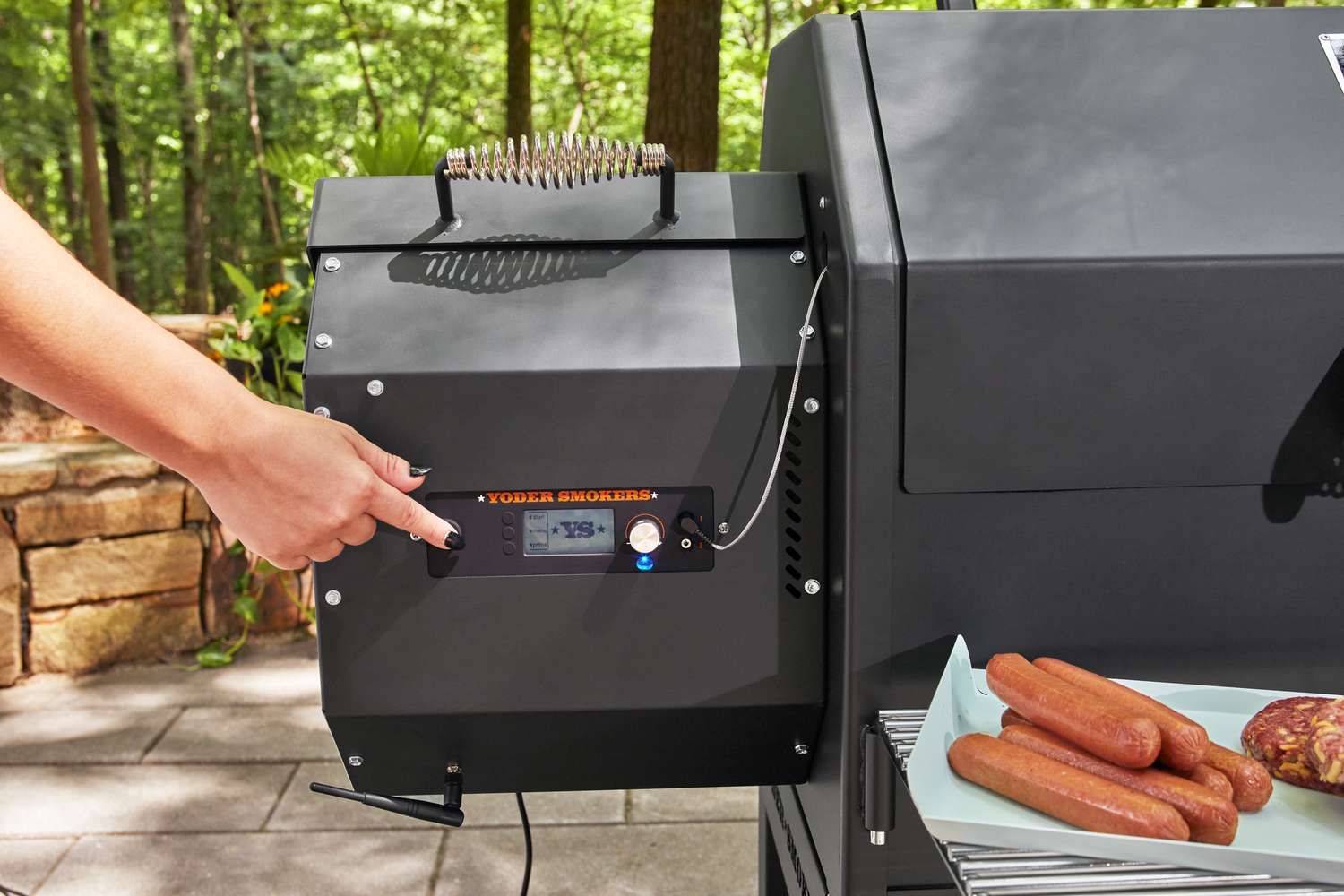 Person pressing a button Yoder Smokers YS640S Pellet Grill