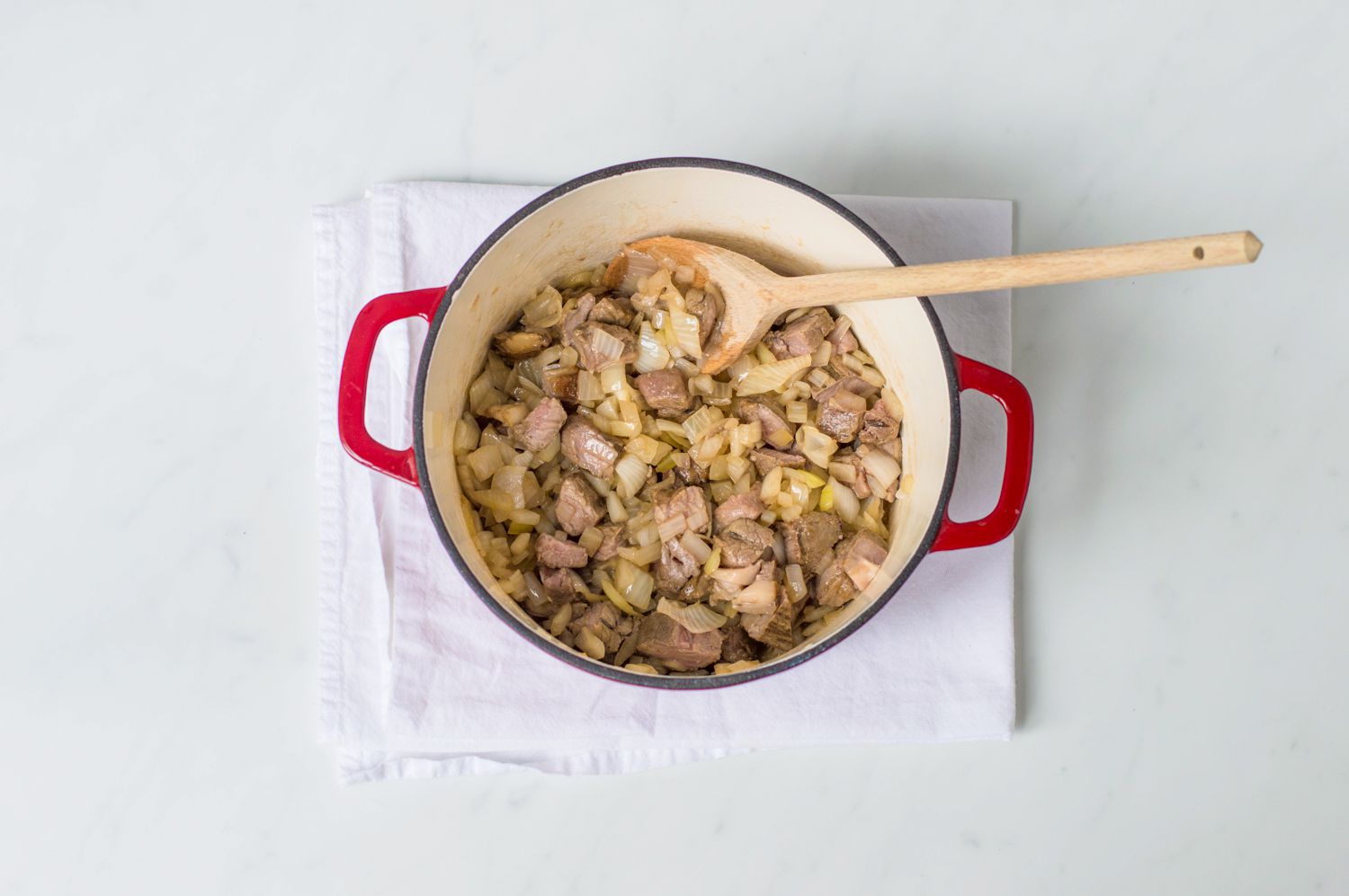 Onions and meat in a Dutch oven for Scottish stovies