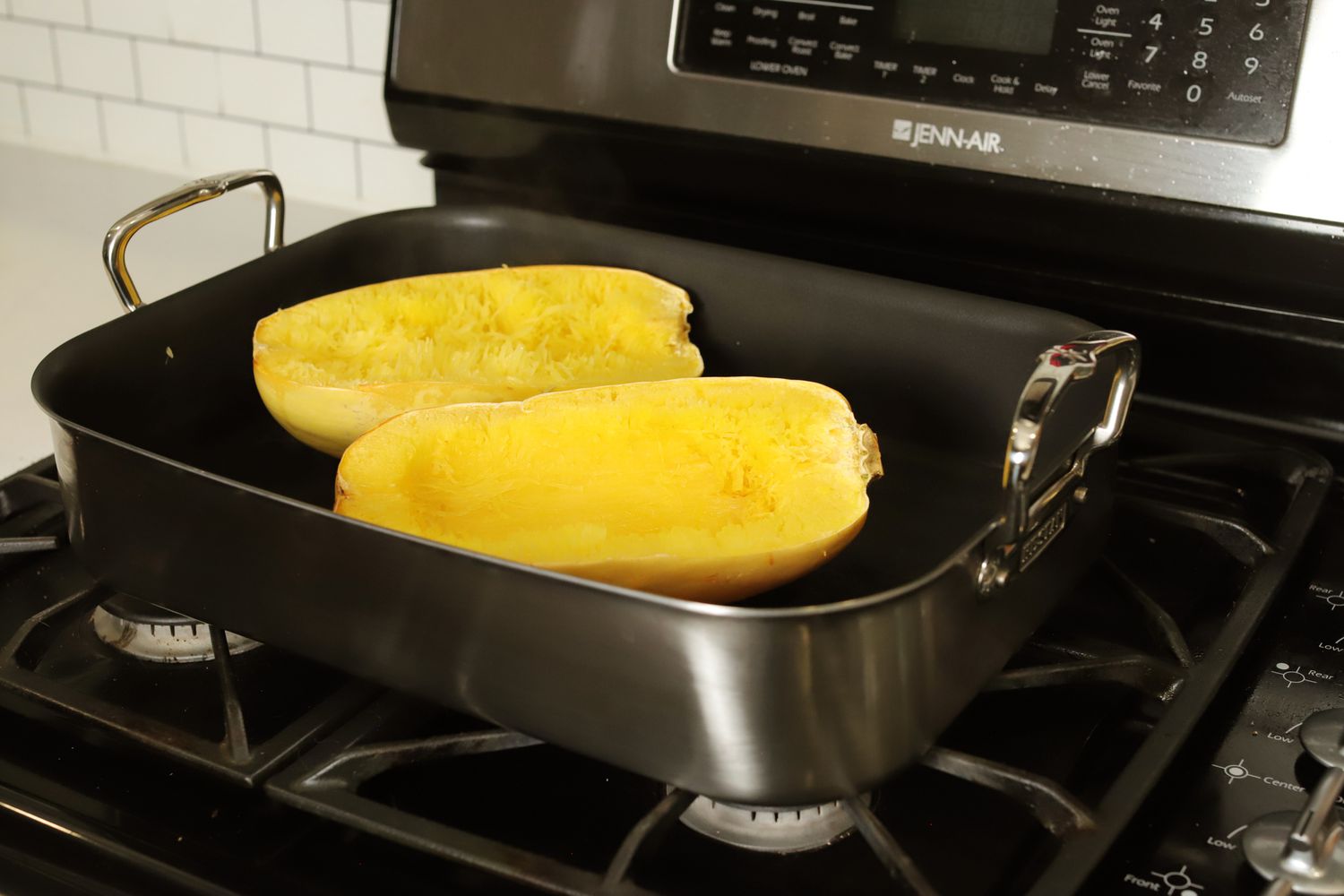 Halved spaghetti squash in the Hestan Stainless Steel Nonstick Roaster, on a gas stove