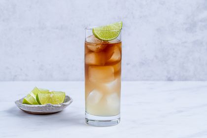 Dark 'n Stormy Mocktail in a glass, garnished with a lime wedge 