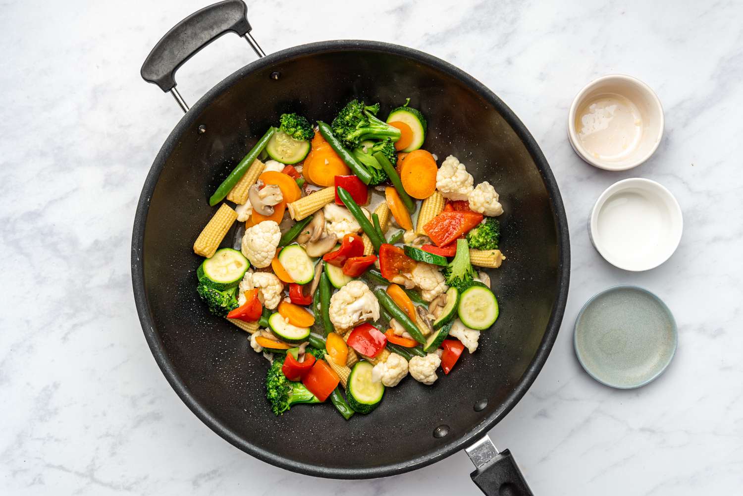 Add the rice wine, fish sauce, white pepper, and salt to the vegetables in the wok