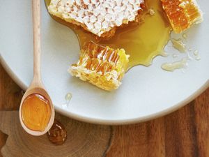 Natural honey comb on plate with spoon