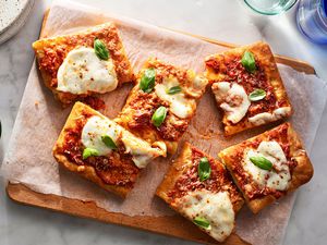 Focaccia Pizza slices on a parchment paper lined cutting board 