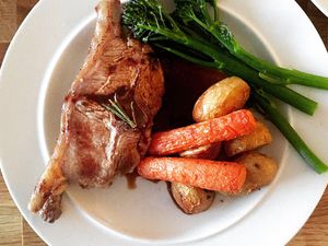 A Barnsley lamb chop with potatoes carrots and broccolini