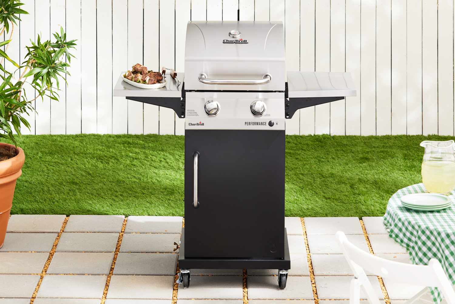 The Char-Broil Performance Series 2-Burner Gas Grill on outdoor tile in front of grass