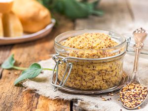 Dijon mustard in a glass jar with a spoon