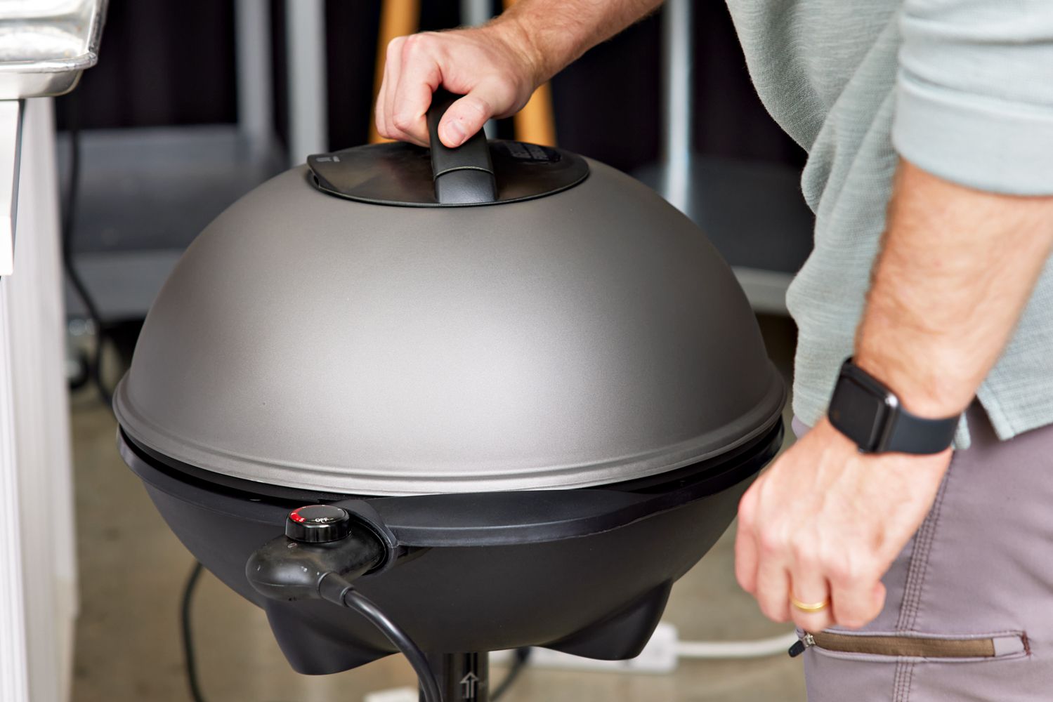 Person holding a closed lid on a George Foreman GFO240S Indoor/Outdoor Electric Grill