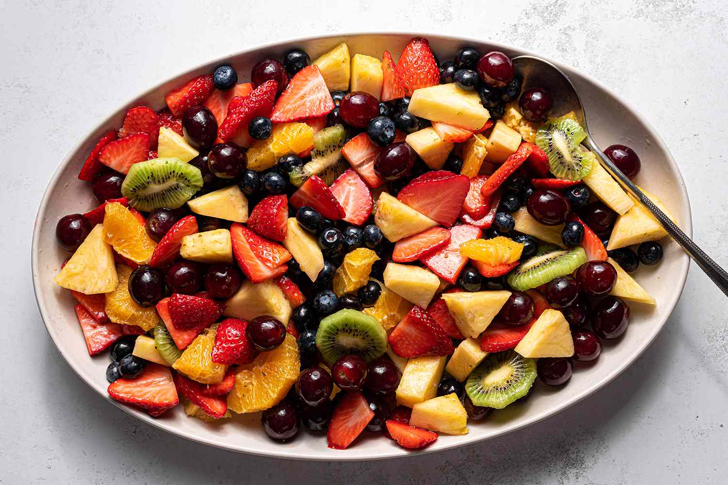 Easy Fruit Salad on a platter with a serving spoon 