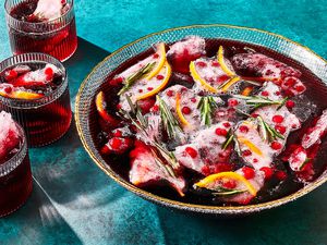 finished punch garnished with ice studded with cranberries, orange zest, and rosemary