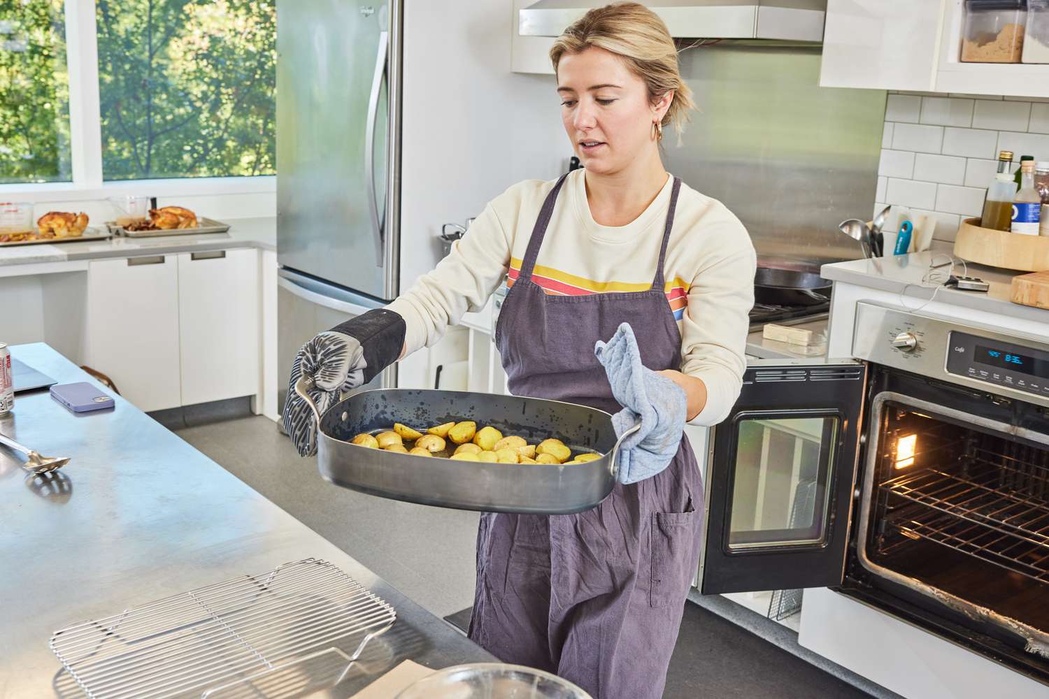 Person carrying the Made In Roasting Pan from the oven to a wire rack